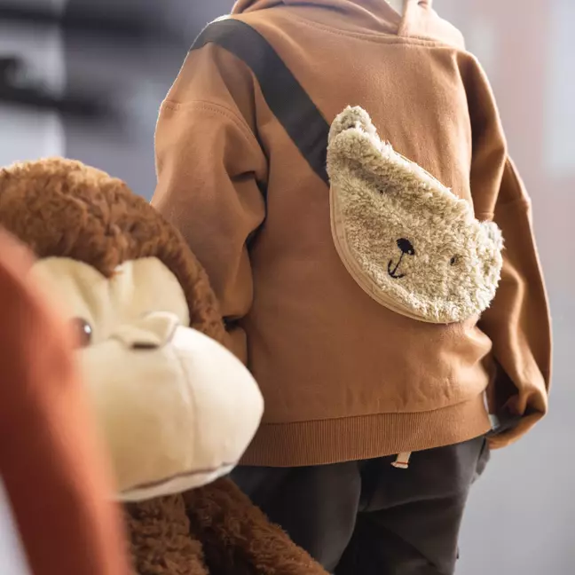 Camisola infantil com bolso de veludo, que simboliza os muitos artigos vendidos na loja online da KiK
