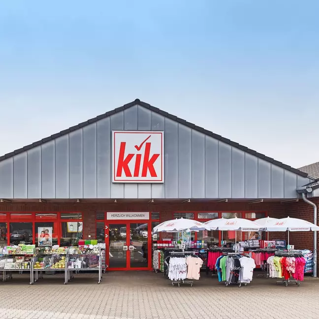 Vista exterior de uma loja KiK com área de vendas ao ar livre, como símbolo das nossas lojas em toda a Europa