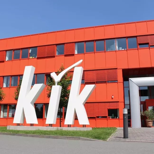 Área de entrada da sede da KiK em Bönen, com um grande logótipo da KiK